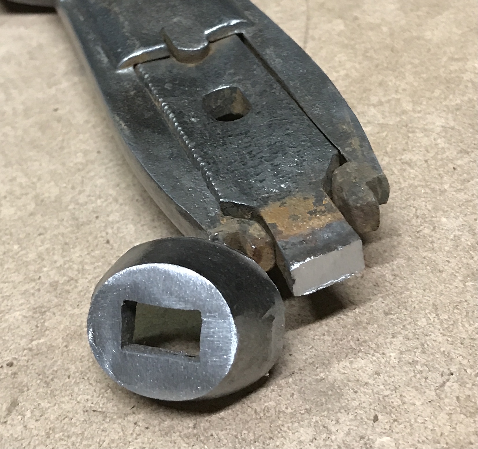 The cap removed from the end of the wrench